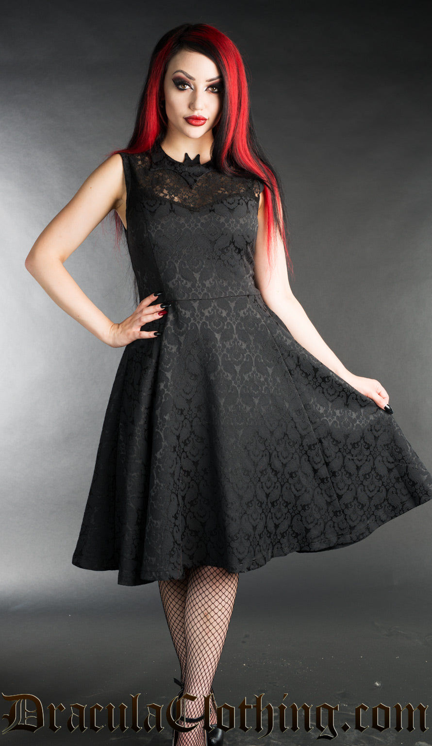 Black brocade knee length dress with lace chest and bat shaped collar worn by model