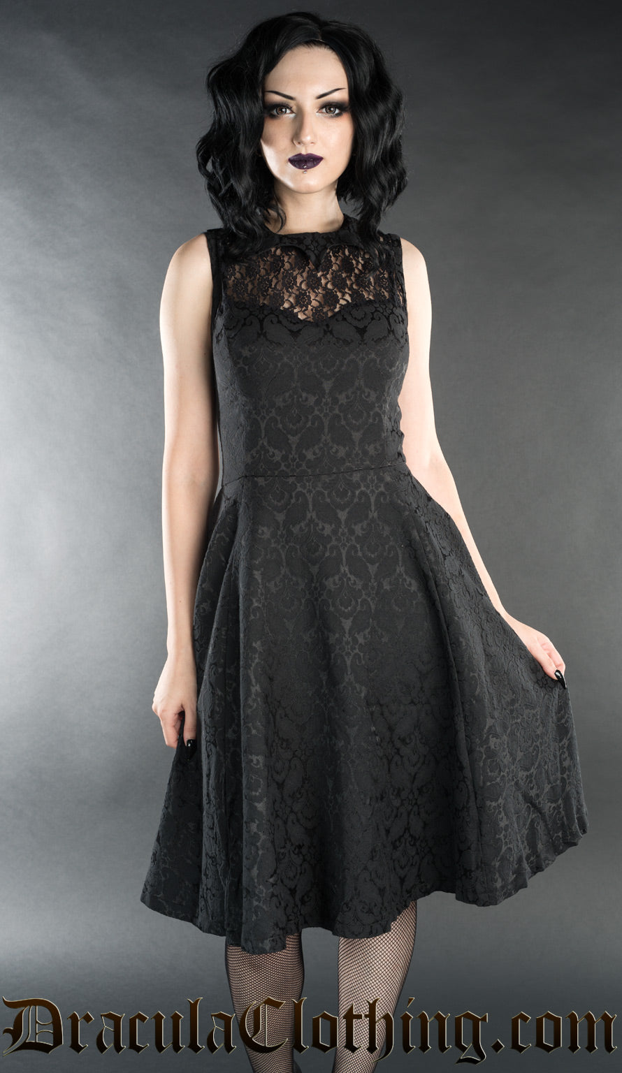 Short black brocade bat dress worn by model