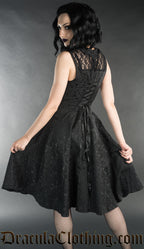 Model showing back of knee length bat black brocade dress with adjustable corset style lacing in the back