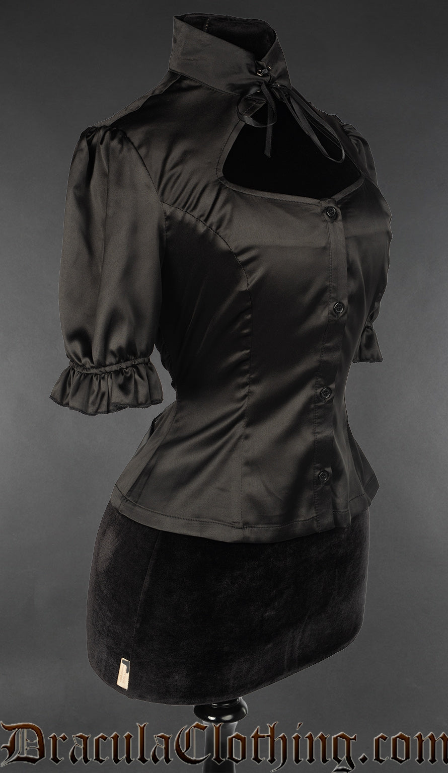Side view of black satin women's blouse showing open keyhole chest panel and short frilled sleeve cuffs