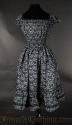 Back view of black skull print women's dress showing highly elasticated waist and black lace trim on neckline