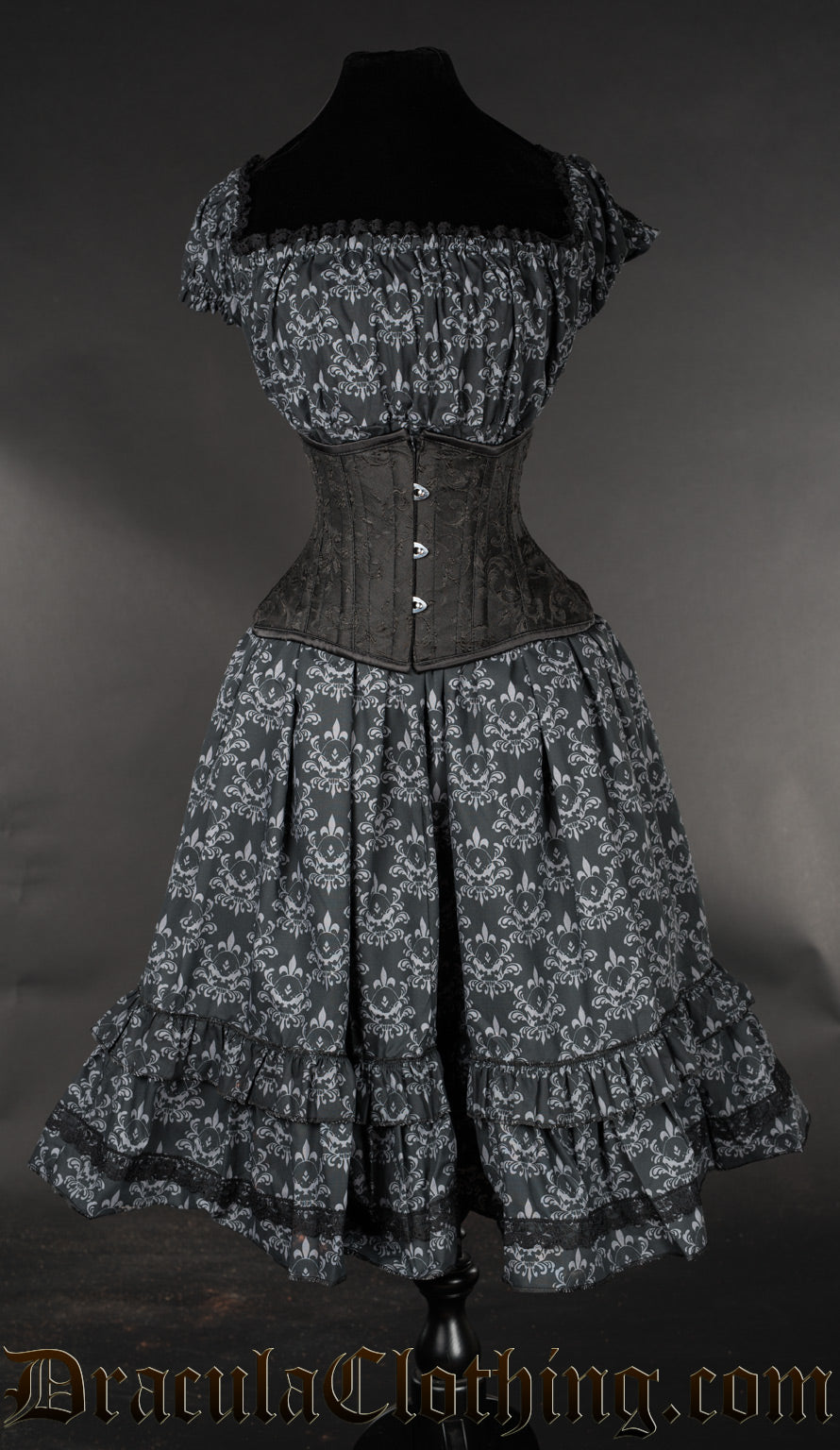 Front view of printed skull pattern black and grey women's dress with elasticated bust shown with additional waist cincher
