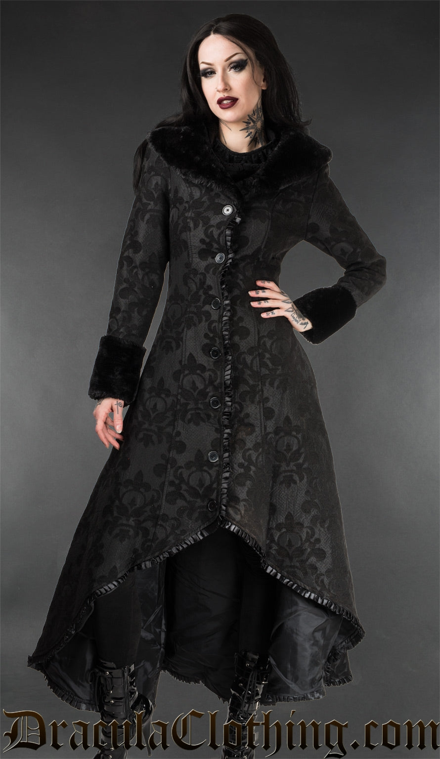 Model wearing women's black skull brocade high low coat with satin lining and ruffled trim along the hem