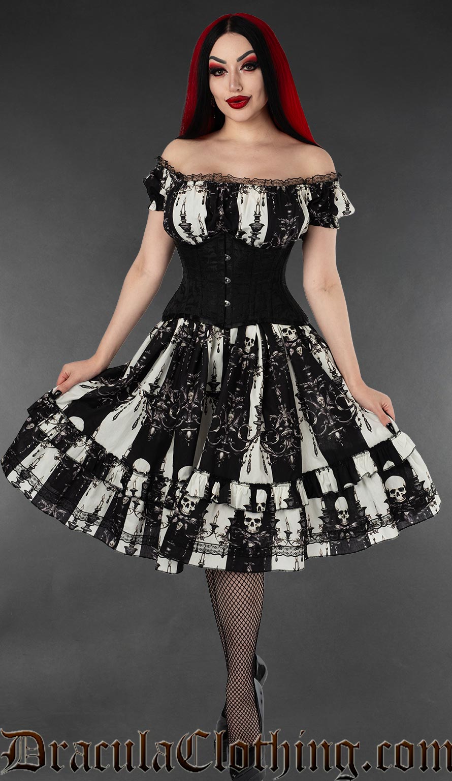 Model wearing black and white striped knee-length dress with skull and candelabra in an off shoulder style