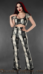Model wearing black and white skull striped velvet flare pants with matching gothic crop top