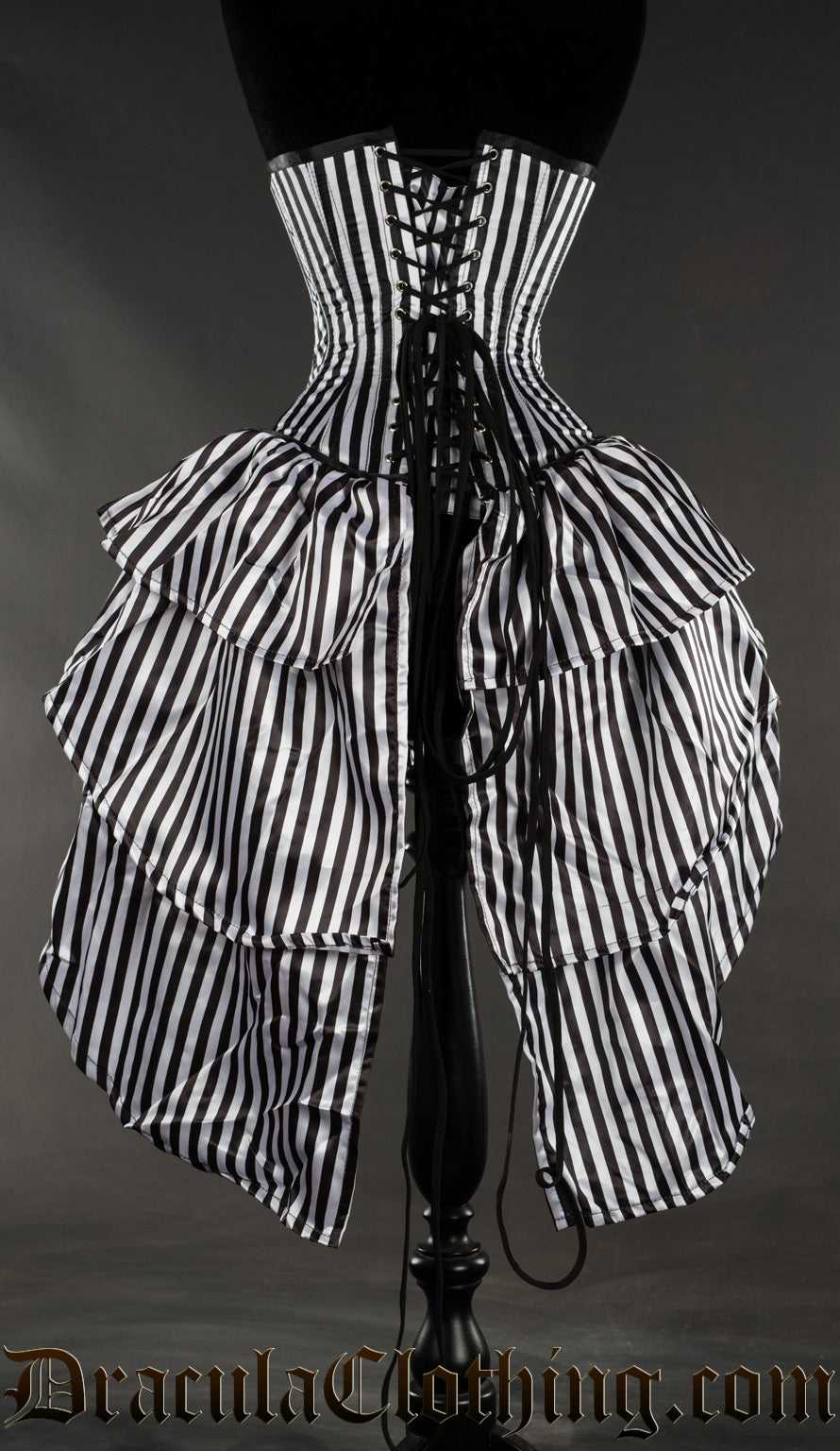Back view of black and white vertical striped corset showing bustle skirt attachment and adjustable lacing with modesty panel