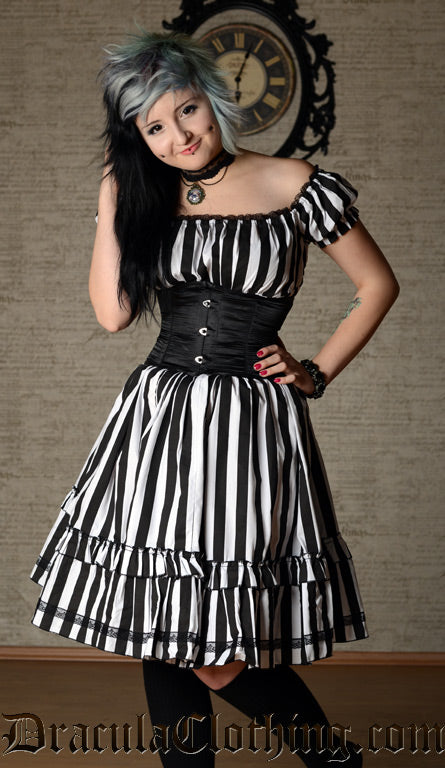 Knee length black and white striped women's dress with black lace details worn with a waist cincher