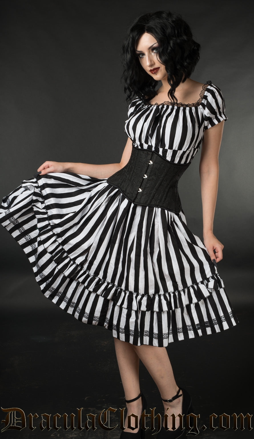 Knee length black and white vertical striped women's dress with a square neckline shown on a model with a waist cincher