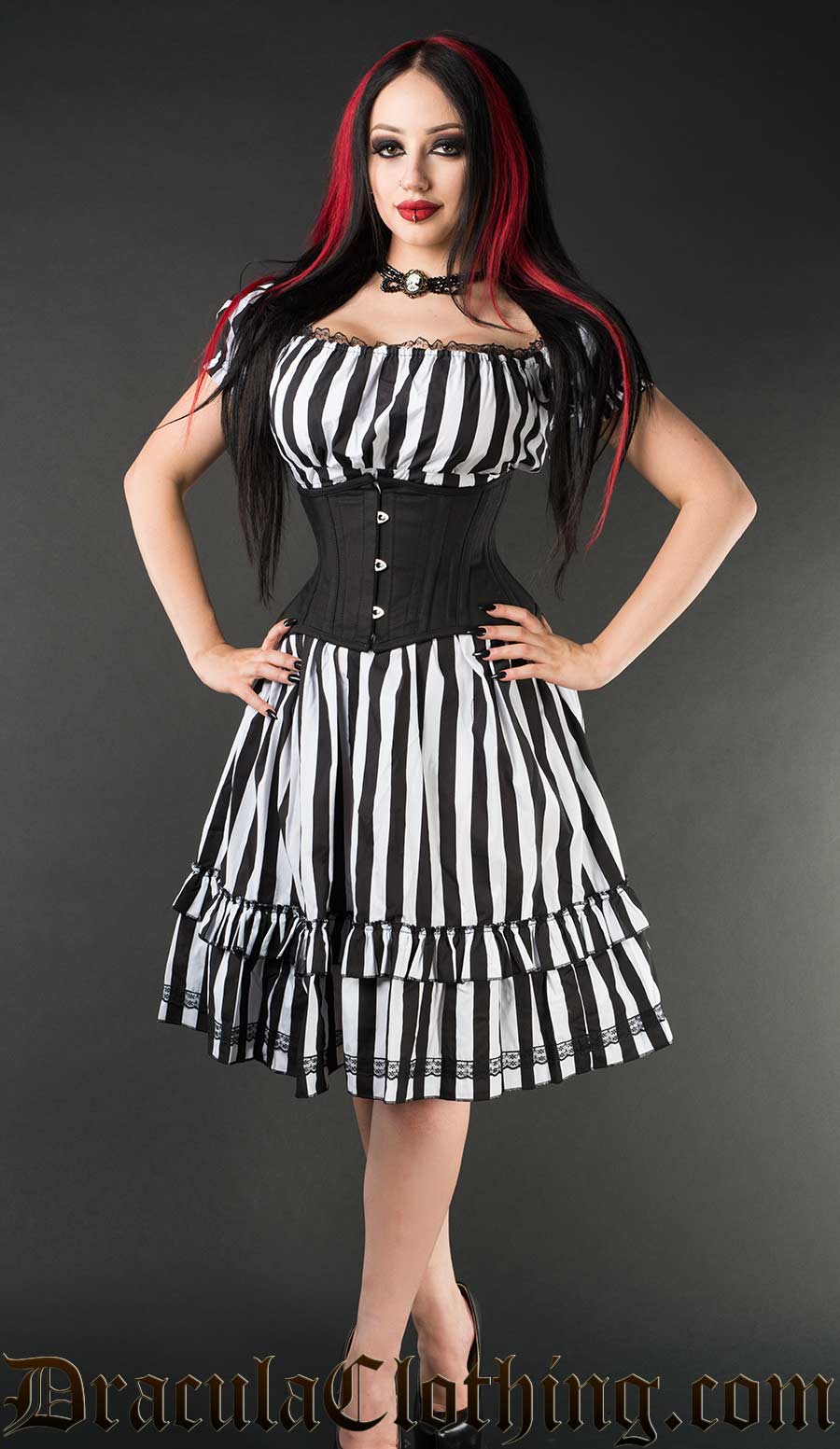 Women's knee length dress made with cotton in black and white vertical stripes shown on a model with a waist cincher and worn off shoulder