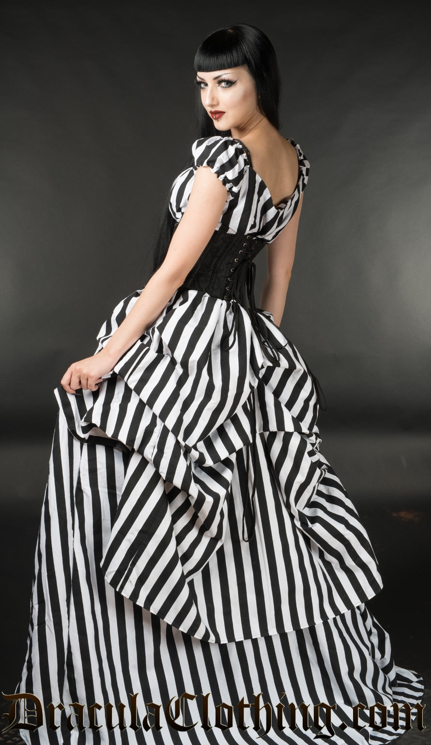 Back view of women's floor length striped dress with layers of fabric in the back for a vintage style shape
