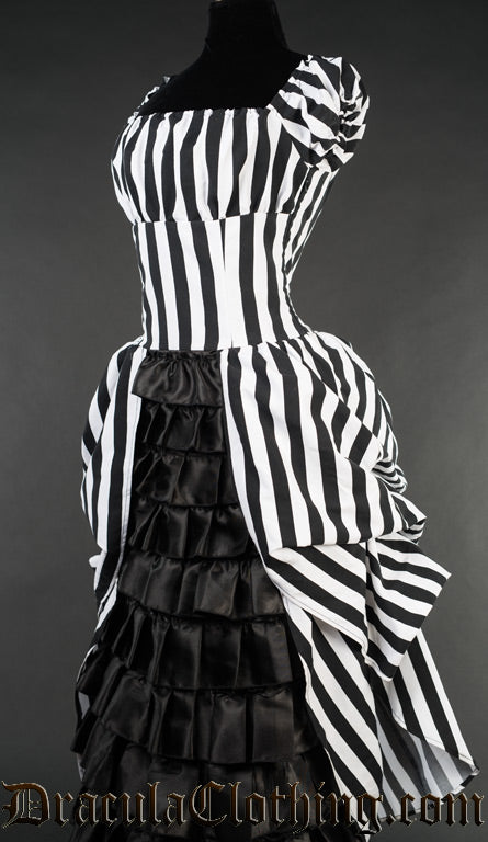 Side view of women's striped long dress with square neckline and black satin ruffled skirt panel in the centre