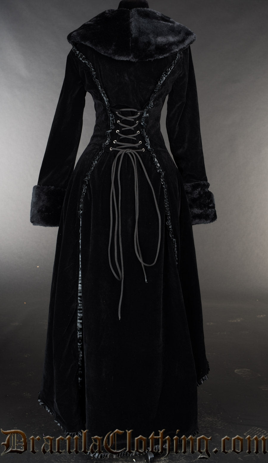 Back view of women's black velvet and faux fur coat showing long back frilled satin trim accents and adjustable corset lacing