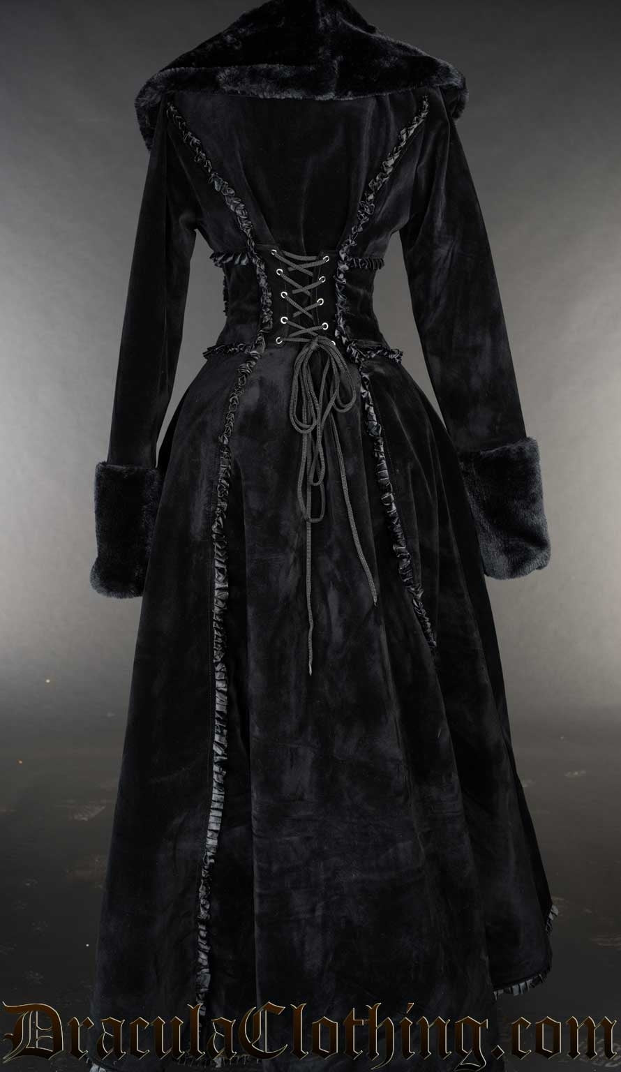 Back view of women's black velvet winter coat with satin details and faux fur trim showing adjustable corset style lacing 
