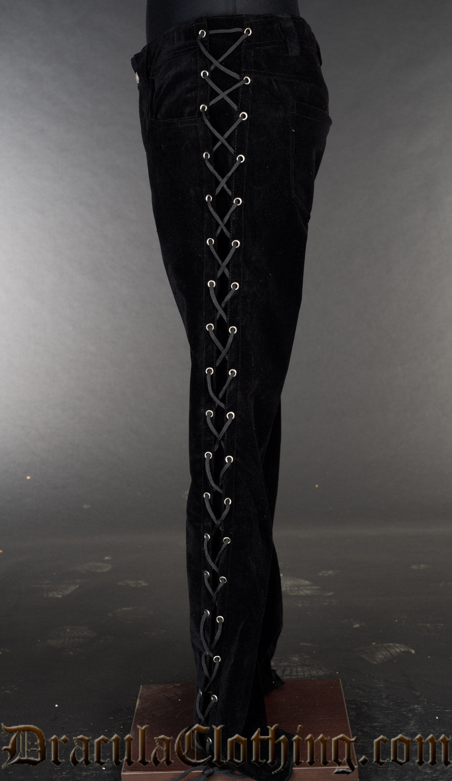 Side view of men's black velvet pants showing lacing in the side of the leg
