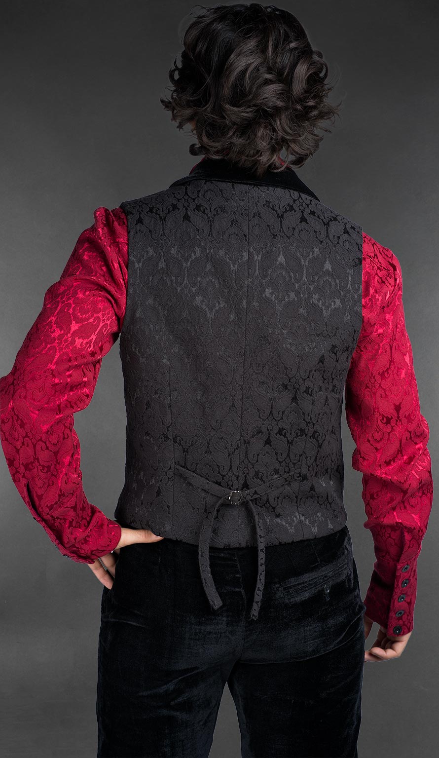 Back view of Men’s black brocade gothic vest with black velvet lapel, worn over a red patterned shirt, Victorian alternative fashion