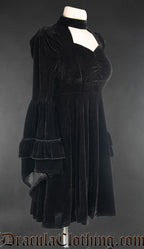 Side view of black velvet women's dress showing layered flared trumpet sleeves and puffed shoulders