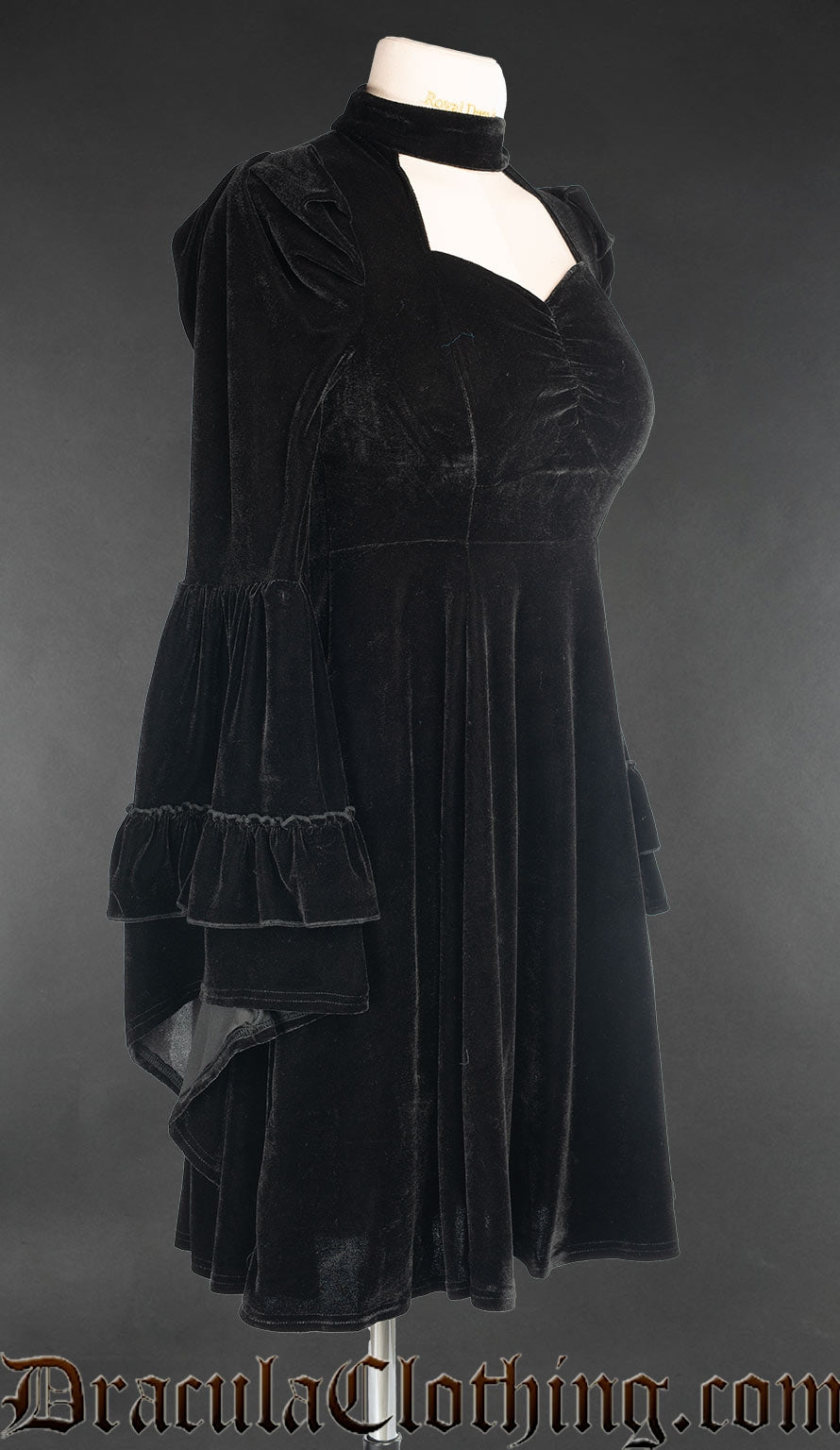 Side view of black velvet women's dress showing layered flared trumpet sleeves and puffed shoulders