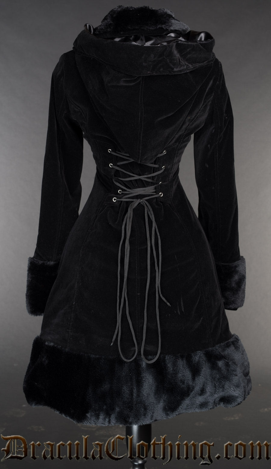 Back view of women's black velvet coat shown without the attachable cape and adjustable corset style lacing in torso