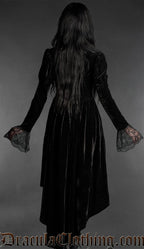Woman wearing a black gothic velvet vampire dress with sweetheart neckline, lace bell sleeves and high-low hem back view