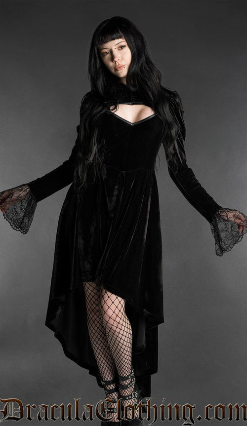 Woman wearing a black gothic velvet vampire dress with sweetheart neckline, lace bell sleeves and high-low hem