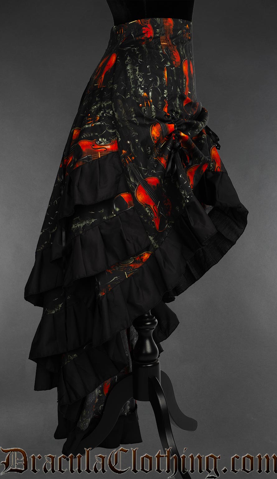 Side view of women's layered black bustle skirt with violin design showing three layers at the back each with black cotton hem