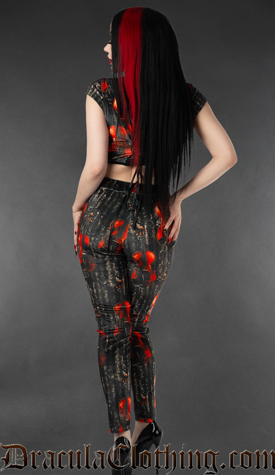 Back view of high waisted fitted velvet leggings with violin print on a black and grey background