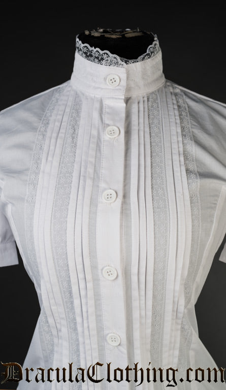 Close up of women's white blouse showing white lace trim on high neck collar and pleated design with added lace details