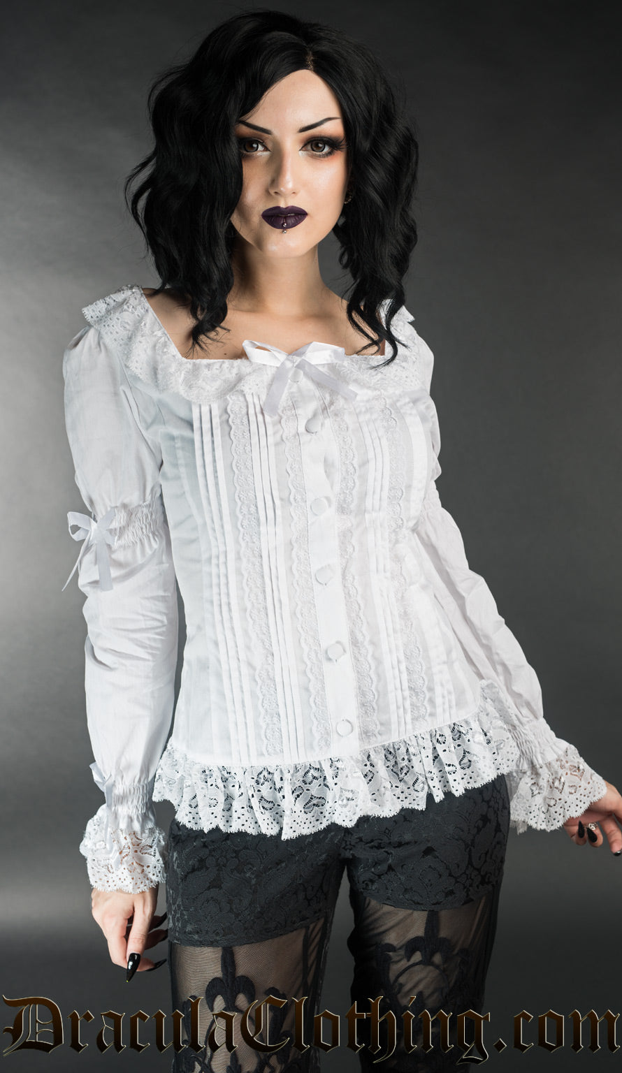 Model wearing long sleeved cotton blouse with frilly lace details and bows