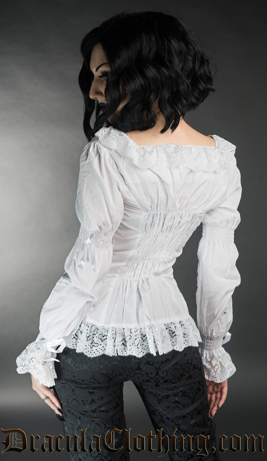 Model showing back of white women's long sleeve blouse with elasticated back and square neckline with lace trim
