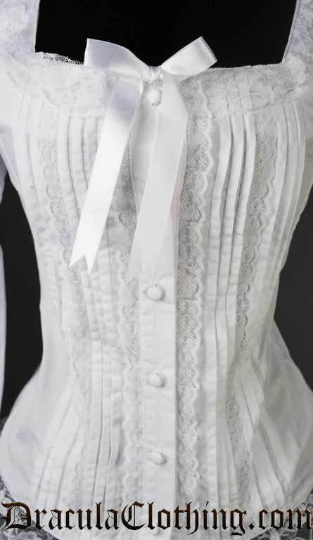 Close up of front of women's white blouse showing pleated design and lace details 